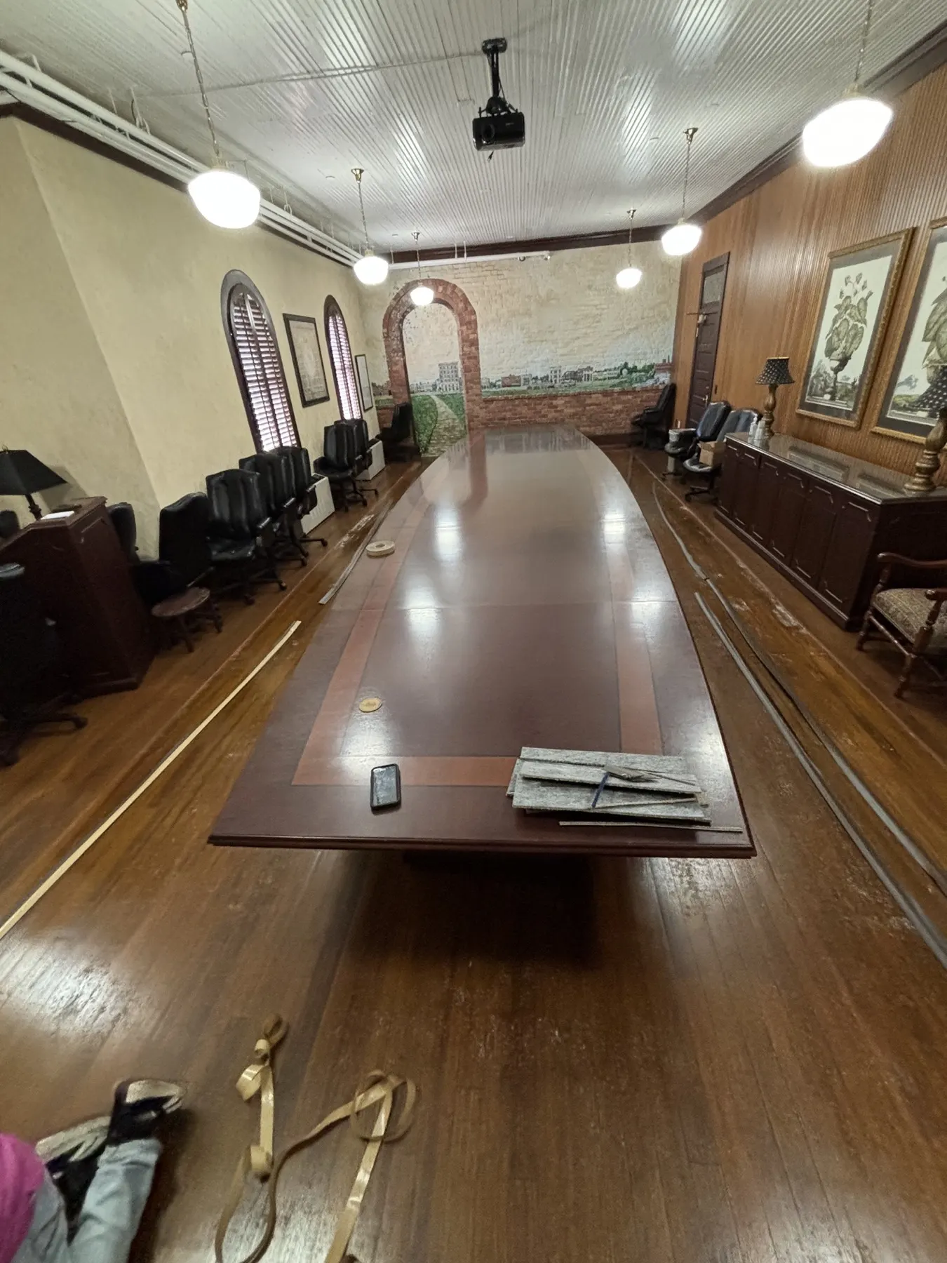 Historic boardroom with a long conference table on bare original hardwood floors