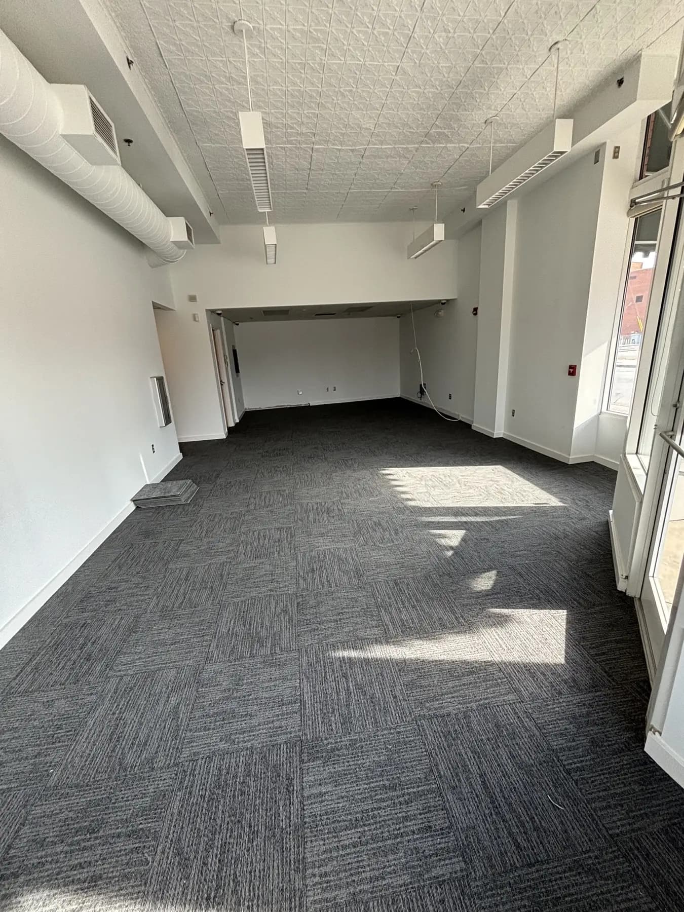 The same storefront space finished wall to wall in charcoal carpet tile