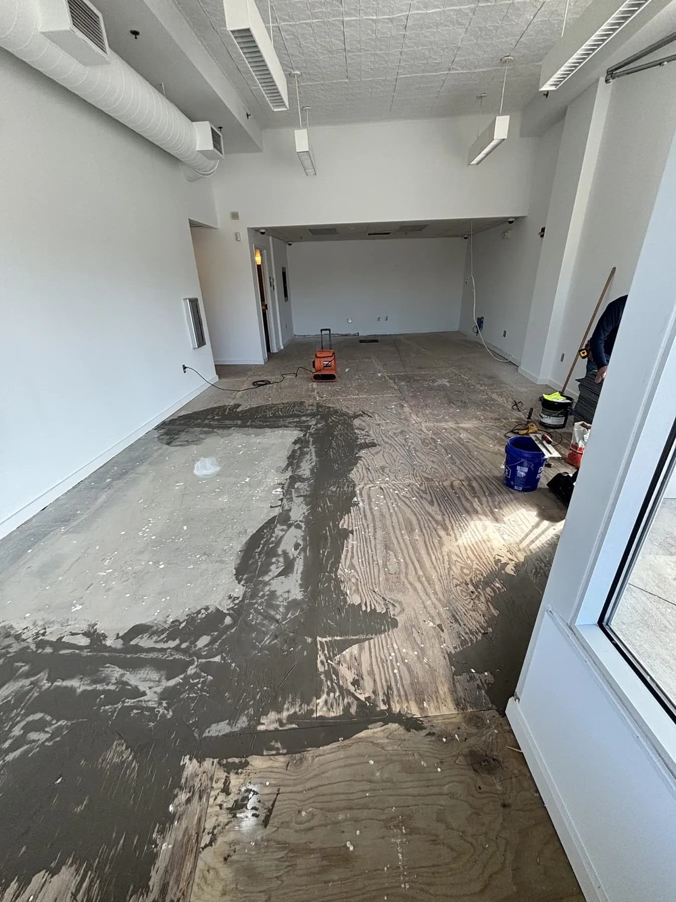 Storefront space with old adhesive and patched concrete on the floor